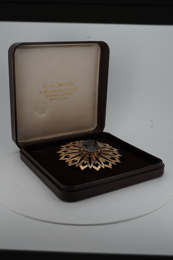 A smoky quartz brooch, set with a circular-cut smoky quartz, within a floral gold surround, 5.7cm diameter, stamped 9CT, maker's mark JF, stamped IVSS, gross weight 17 grams